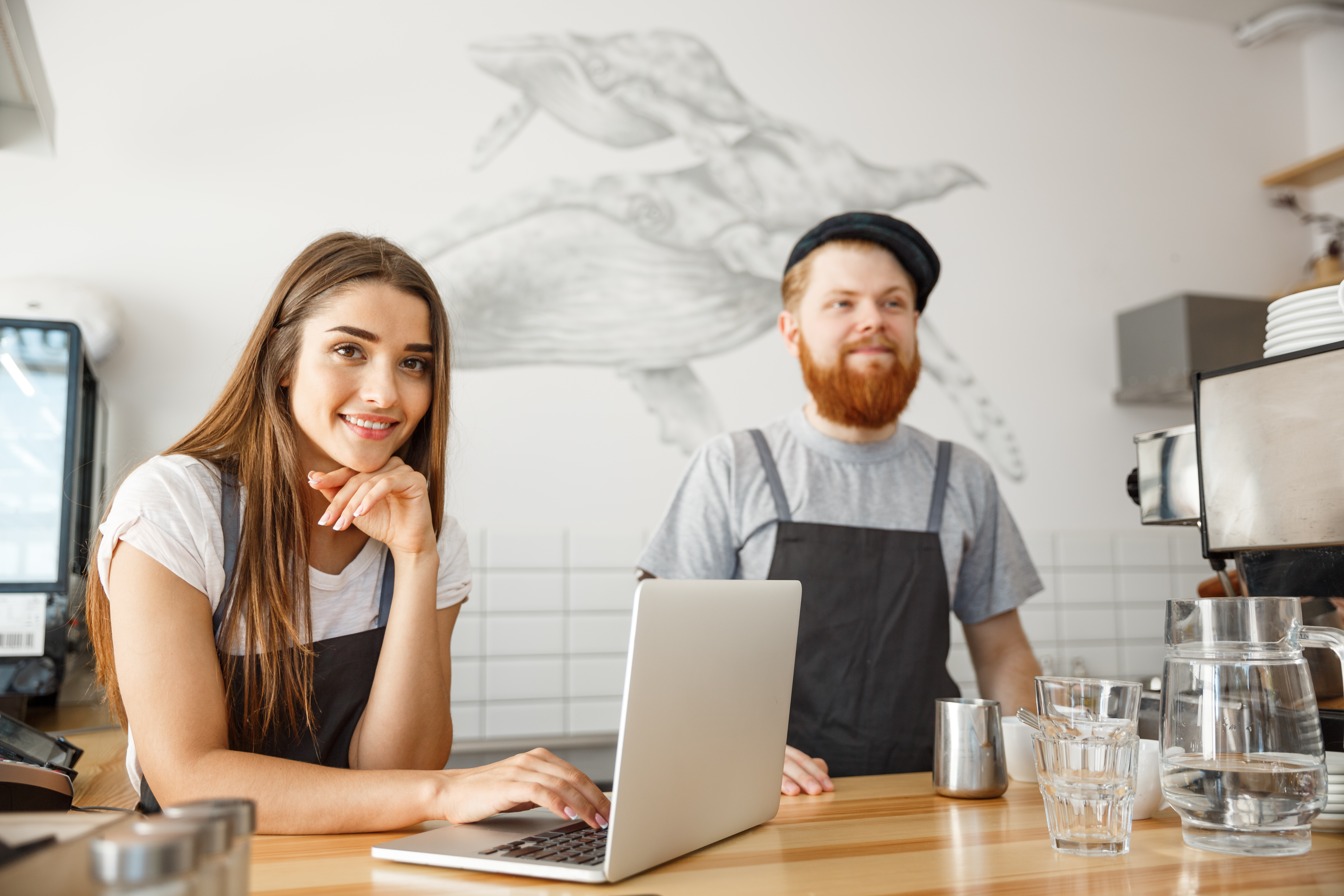 Small Florida coffee shop owners at their laptop comparing SHOP and private small group health insurance options