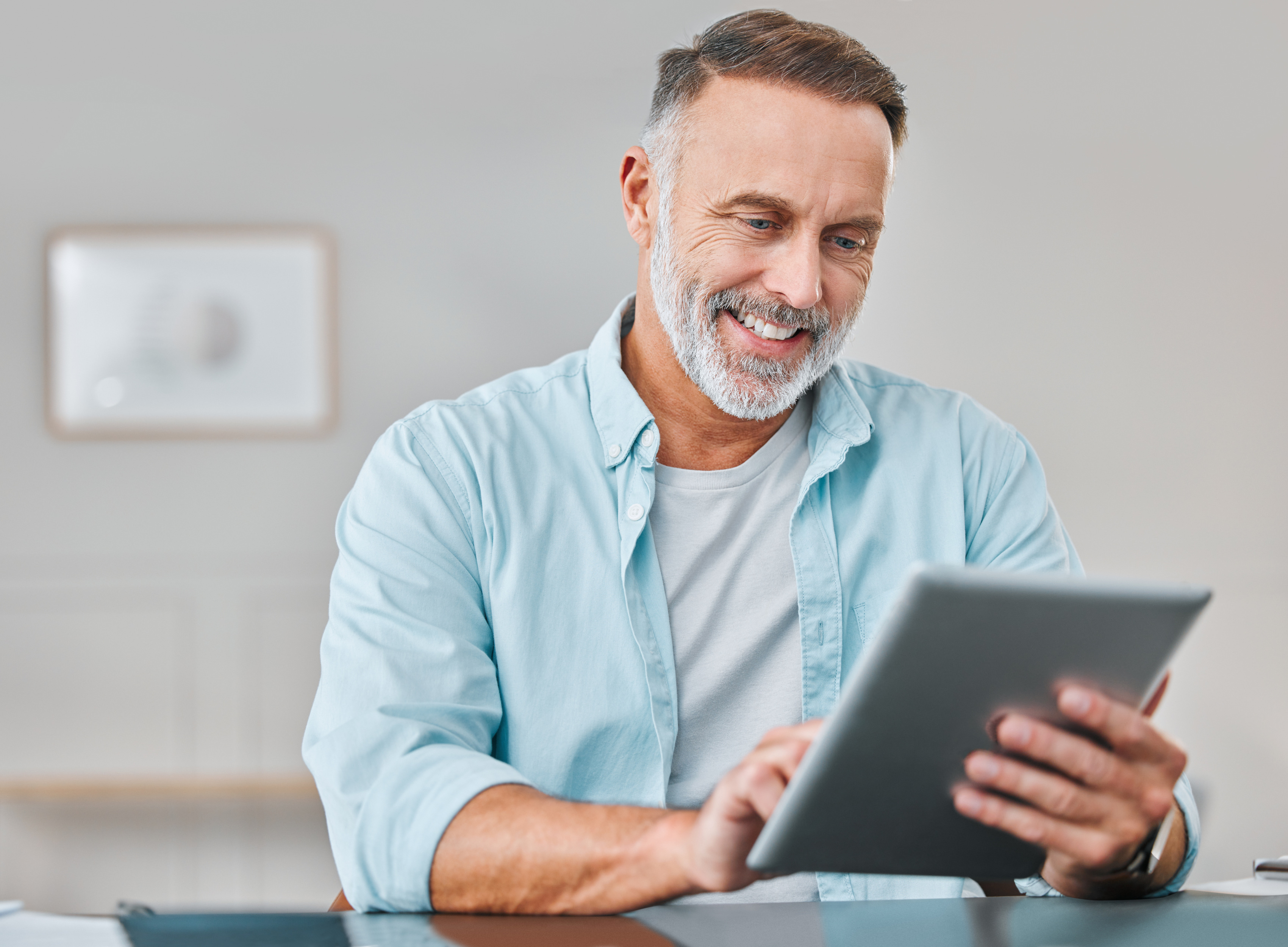 Man using a tablet to research health insurance options from a home office