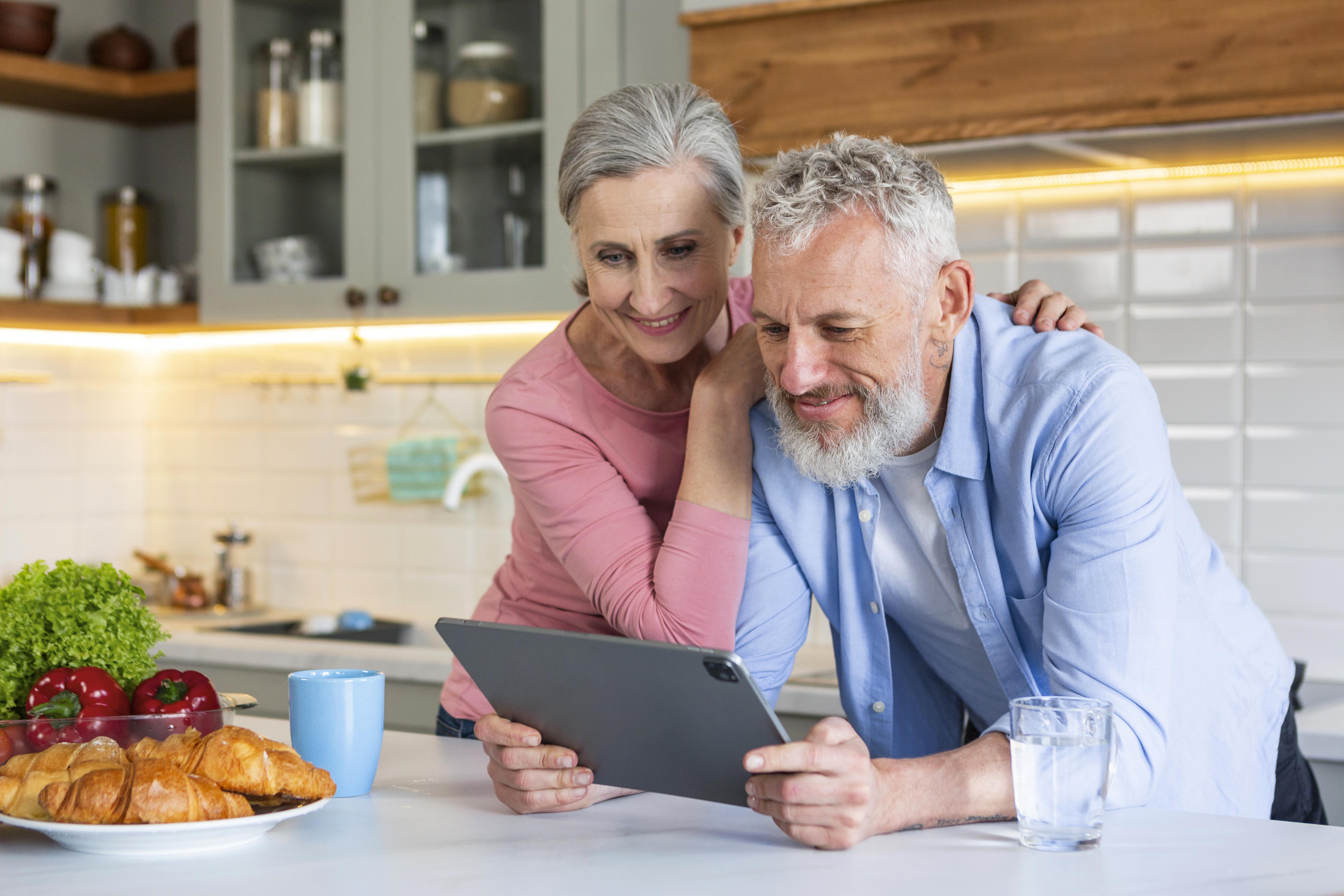 A senior couple comparing Medicare Advantage and Medicare Supplement options together on a tablet